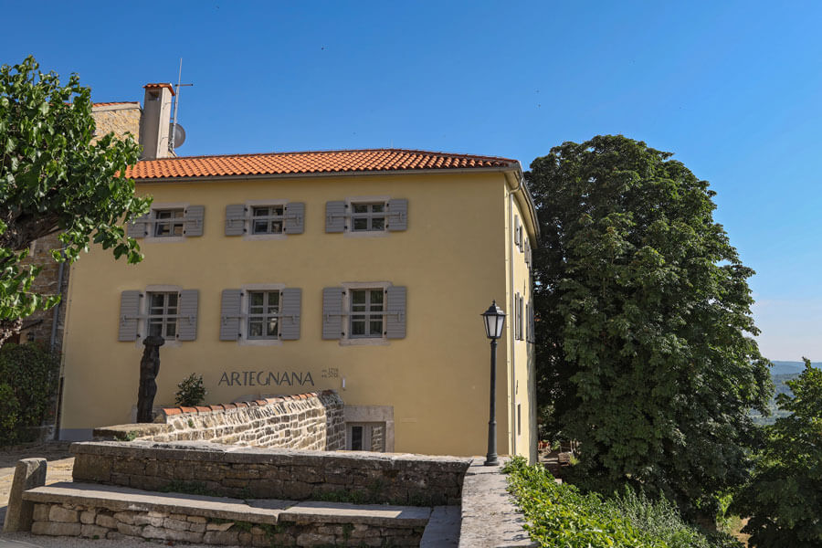 Artegnana 1798 yellow facade with grey shutters and terracotta roof in Grožnjan