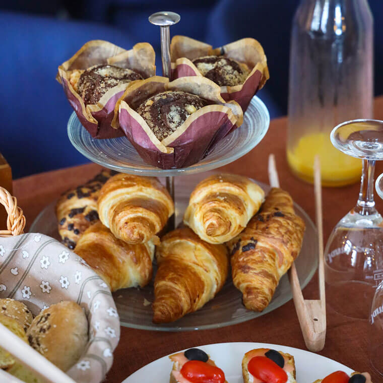 Tiered stand with golden croissants and homemade muffins at Bistro Artegnana